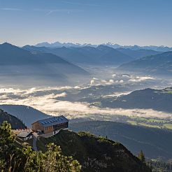 Blick auf Hütte mit sanften Nebelschwaden im Tal