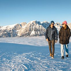 Pärchen schlendert auf Winterweg im Hintergrund Nebelmeer und Bergkette