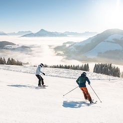 Skifahrer und Snowboarder auf Skipiste